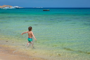 güzel, beyaz plaj mavi gökyüzü mavi denize çocuk çalışır