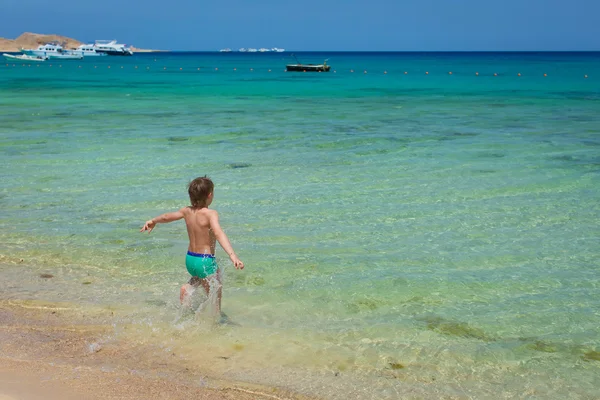 güzel, beyaz plaj mavi gökyüzü mavi denize çocuk çalışır