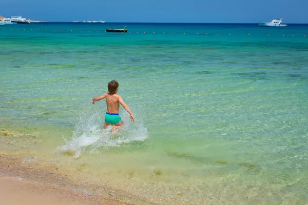güzel, beyaz plaj mavi gökyüzü mavi denize çocuk çalışır