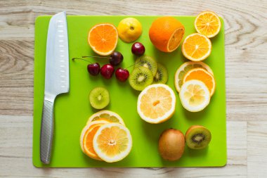 Beyaz ahşap bir masa üzerinde bir tahta üzerinde taze narenciye kesilmiş . 