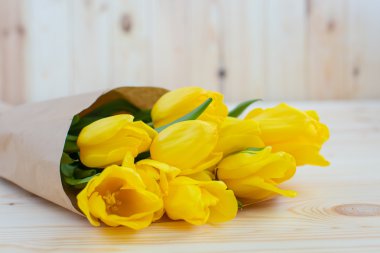 Tahta bir yüzeyde sarı laleler