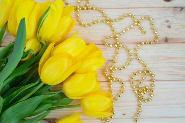 Tahta bir yüzeyde sarı laleler