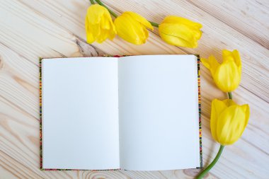 Sarı laleler ile ahşap arka plan üstünde defter