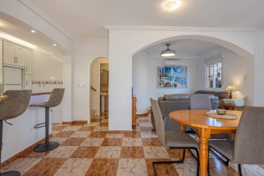 Parlak ve rahat yaşam ve yemek alanı mermer döşeme, nötr tonlar ve kemerli detaylar.