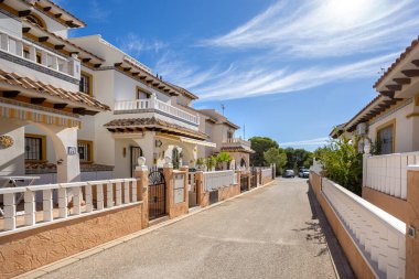 Charming Mediterranean tarzı evler, beyaz cepheli, terasotta çatıları, balkonları ve ön bahçeleri olan sessiz bir yerleşim yeri..