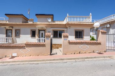 Bej renkli Akdeniz manzaralı, taş süslemeli ve kapısı açık bir ev.