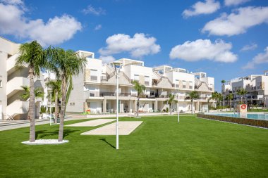 Uzun bir balkon, yemek odası ve manzaralı bir yerleşim yeri manzarası.