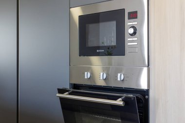 Paslanmaz çelik mikrodalga fırın ve dijital ekran ve kontrol düğmeleri.