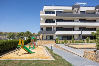 Çağdaş konut kompleksi. Renkli oyun alanı yeşillik ve açık güneşli havayla çevrili.