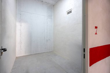 Beton duvarları ve zemini olan mobilyasız depo. Güvenli otoparkın içinde.