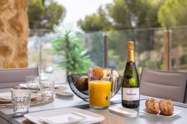 Meyve suyuyla, şampanyayla, ekmeklerle ve meyve tabağıyla şık kahvaltı seti.