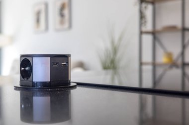 Parlak mutfak adasında USB portları ve elektrik prizi olan açılır kapaklı soket.