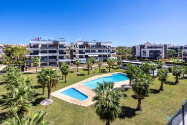 Amanecer, Torrevieja, İspanya 'da yüzme havuzları ve palmiye bahçeleri olan modern konutlar.