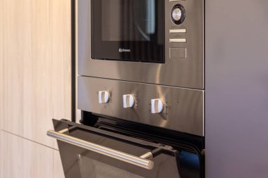 Modern Amanecer apartmanlarının mutfağında kontrol düğmeleri olan paslanmaz çelik fırın, Torrevieja.