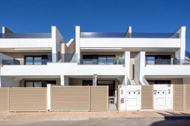 Balkonlar, merdivenler, kapılar ve temiz mimari tasarım içeren çağdaş çok katlı konut cephesi