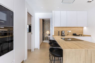 Çağdaş mutfak, parlak tasarım, ahşap yüzeyler ve taş duvarlı yatak odası manzarası.