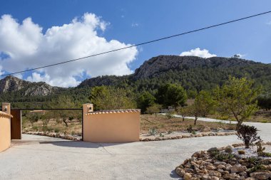 Taş duvarlı giriş, dağ manzaralı ve doğal manzaralı manzaralı manzaralı bir yere açılıyor.