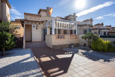 Parlak Akdeniz konak evinin dış yüzeyi fayanslı veranda pergola bahçesi ve açık güneşli gökyüzü