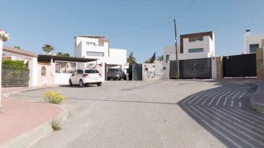 Güneşli muhitlerde bahçeli ve palmiye ağaçlı modern villanın insansız hava aracı geçidi.