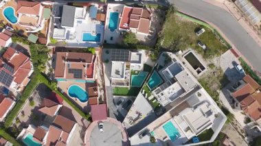 Havuzu, güneş panelleri ve modern mimarisi olan banliyö evleri üzerinde dönen insansız hava aracı görüntüleri