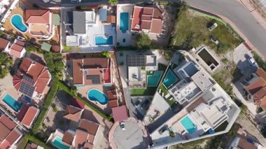 Havuzu ve güneş paneli çatısı olan konut evlerinin tepeden aşağı insansız hava aracı görüntüsü