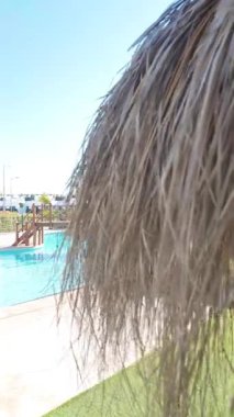 Turkuaz yüzme havuzunun üstündeki tahta köprünün dikey görüntüsü