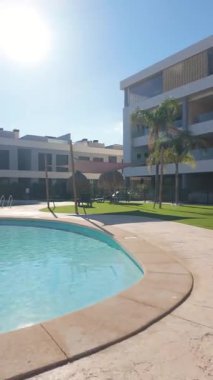 Tahta köprüsü olan güneşli yüzme havuzunun dikey görüntüsü