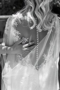 Dantel elbiseli gelinin yakını damatlara yüzük takıyor kırmızı takım elbiseli adam yeminlerini ederken.