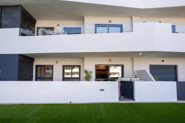 Kapalı avlu ve konut kompleksinde yapay yeşil çimlerin bulunduğu modern zemin kat dairesi