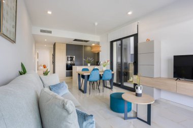 Parlak açık iç plan mutfak, yemek alanı, rahat oturma odası ve görünür yatak odası.