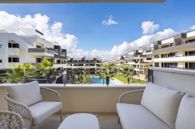 Yastıklı balkon ve manzaralı havuz manzaralı konut kompleksi.