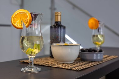 Süslü, siyah bir masanın üstünde, yanında meyve garnitürlü beyaz şarap..