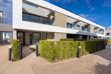 Camdan balkonları, bahçe çitleri ve özel verandası olan çağdaş bir apartman dairesi.