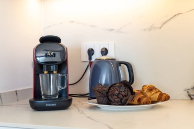 Modern mutfak kahve köşesi espresso makinesi, çaydanlık ve taze kahvaltı hamur işleriyle donatılmış.