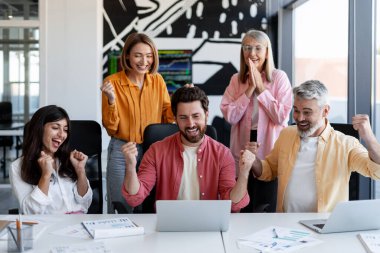 Çeşitli iş adamları masamızda oturmuş zaferle tezahürat yapıyor ve yumruklarını kaldırıyor. Dizüstü bilgisayarın başarısını kutluyorlar.
