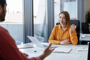 Başarılı güzel kadın, modern ofiste çalışan iş kadını iş yerinde sakallı adamla konuşuyor. İki meslektaşım proje planlıyor. İş konsepti