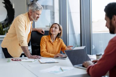 Başarılı iş adamlarının portresi, kendine güvenen iş adamları ve iş kadınlarından oluşan bir grup birlikte modern işyerinde çalışıyorlar, dizüstü bilgisayar işi kavramını kullanıyorlar.