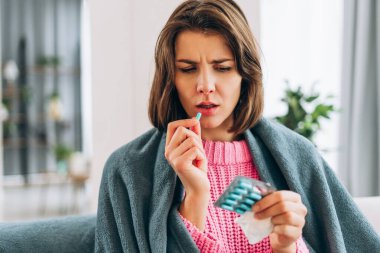 Kadın hasta, tedavi için battaniyenin altında ilaç alıyor.