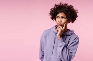 Yakışıklı, dalgın, sıradan kıyafetler giyen Amerikalı genç adam pembe arka planda izole edilmiş fotokopi odasına bakıyor. Alışveriş konsepti