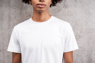 Yakından özgün, beyaz t-shirt giyen Afro-Amerikan bir adam. Gri arka planda izole edilmiş bir kopya alanı. Reklam kavramı