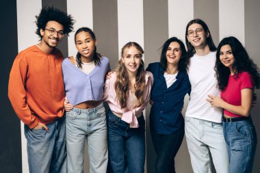 Group of happy young adult friends standing together, celebrating unity and modern lifestyles