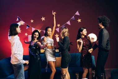 Genç yetişkinler eğleniyor, dans ediyor, kutlama yapıyor ve geceleri birlikte eğleniyorlar.