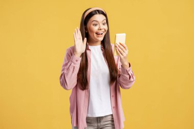 Uzaktan iletişim kuran gülümseyen genç bir kadın, video konferansı sırasında şaşırmış ve heyecanlı hissediyordu.