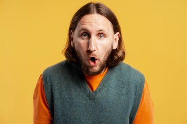 Şaşkın adamın ağzı açık sarı arka planda şaşkınlık ve şok gösteriyor.