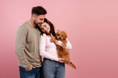 Sevimli bir köpek yavrusuyla mutlu bir aile portresi. Renkli arka planda sevgi ve şefkat gösteriyor.