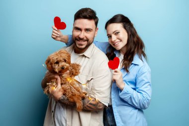 Genç adam ve kadın köpekleriyle poz veriyorlar, Sevgililer Günü 'ne sevgi ve şefkat gösteriyorlar.