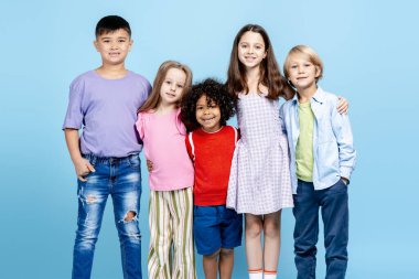 Çocukluk, arkadaşlık ve okul kavramını gösteren çeşitli mutlu çocuklar bir arada duruyorlar.