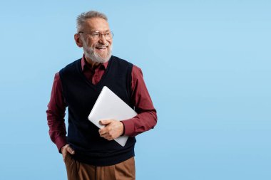 Bilgeliği, başarıyı ve teknolojiyi simgeleyen bir dizüstü bilgisayar tutan mutlu kıdemli adam.