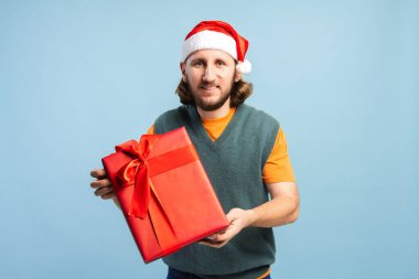 Noel Baba şapkalı adam bayramları neşeli bir ifadeyle kutluyor.