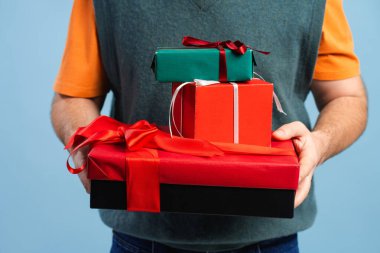 Bir yığın hediye taşıyan bir adam, bayram ruhunu ve şenlik anlarını paylaşıyor.